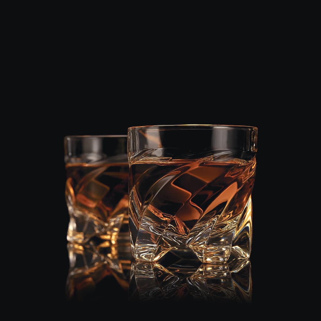 Two SHTOX Edgewave shot glasses with whisky, on black